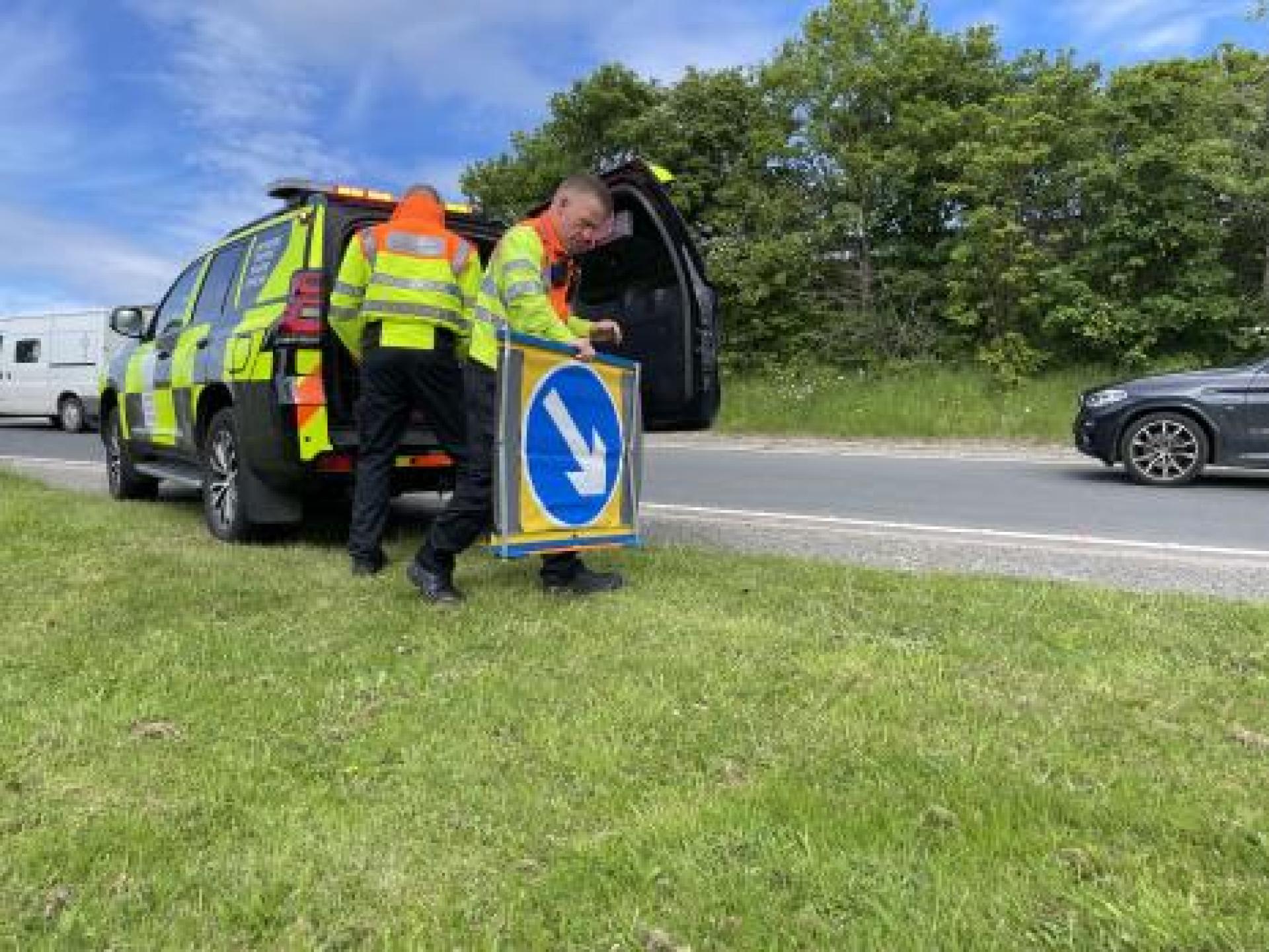 traffic officer deploying sign from back of vehicle